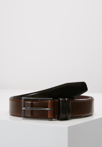 Ceinture en cuir marron, présentant une boucle noire brillante, un design bicolore et une texture lisse, avec un accent en métal argenté.