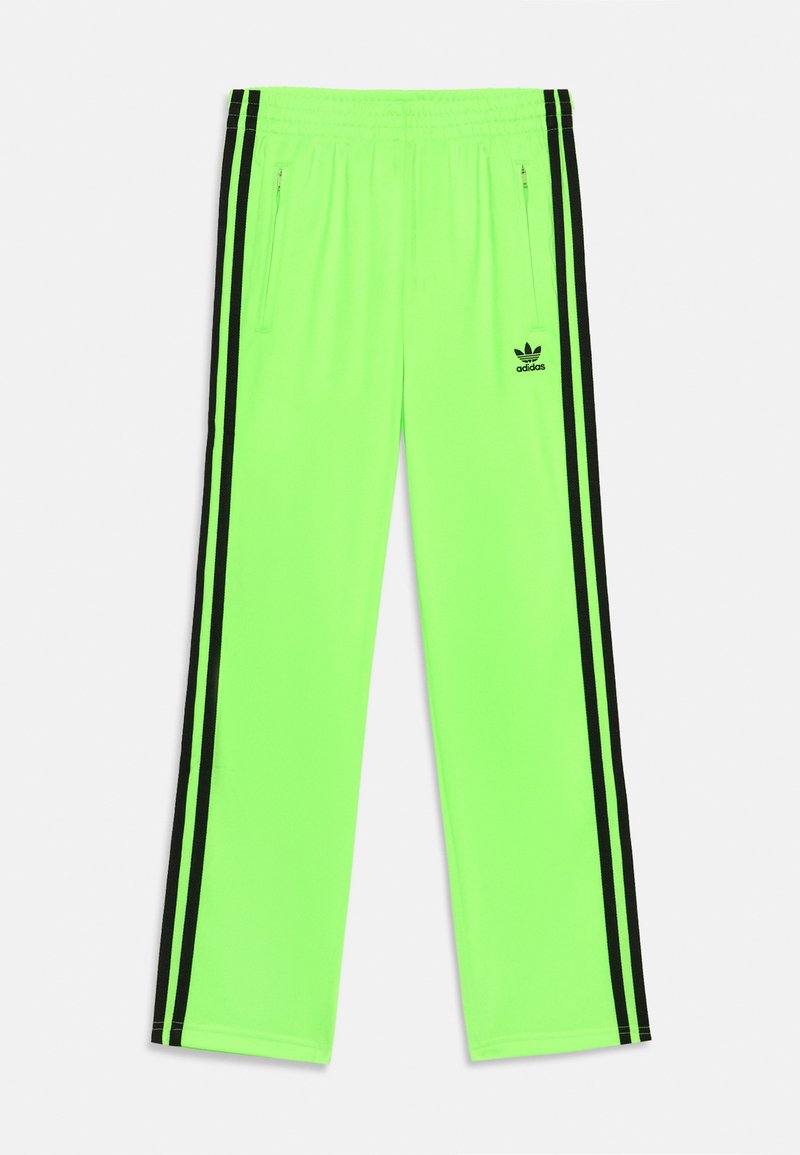 Neon zaļas sporta bikses ar rāvējslēdzēja kabatām, melnām sānu svītrām un mazu melnu logotipu kreisajā kājā. Elastīgs jostasvīts, lai nodrošinātu piemērotību.