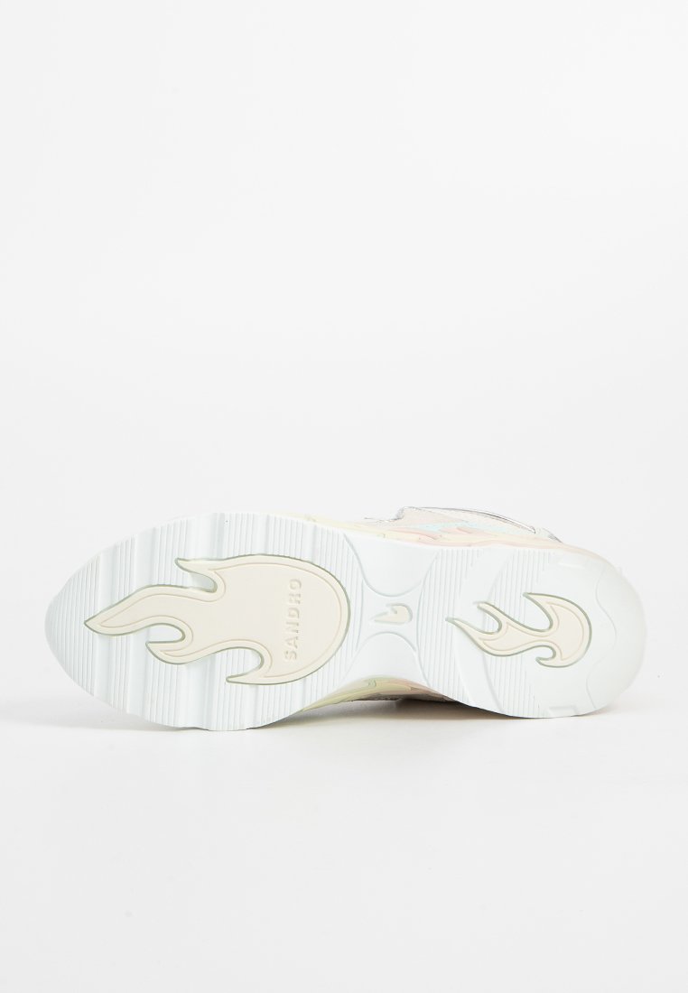 Sneaker z białą gumową podeszwą z wzorem płomienia, gładką pastelową cholewką i odblaskowymi akcentami. Teksturowana powierzchnia i zaokrąglony kształt.