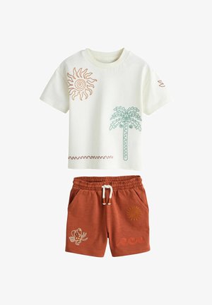 Bijela majica kratkih rukava s vezom sunca i palme, uparena s kratkim hlačama boje hrđe koje imaju vez rakova, sunca i valova.