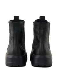 Bottines en cuir noir avec un panneau en feutre gris texturé, semelle épaisse noire et languettes à l'arrière. Design robuste avec des coutures accentuées.