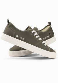 Olivenfarbene Leinensneaker mit weißen Gummisohlen, runder Spitze und weißen Schnürsenkeln. An der Seite steht der Text: "DEIN EINZIGES LIMIT IST DEIN GEIST."