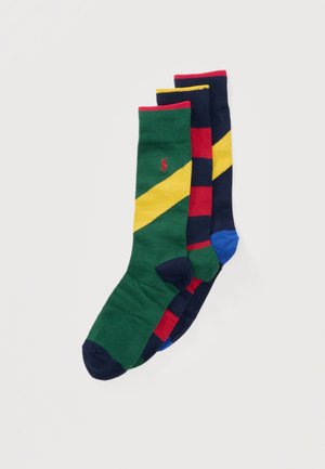 Trīs pāri vidēja garuma zeķu: zaļas ar dzeltenu diagonālu svītru, sarkanas ar tumši zilām svītrām un tumši zilas ar dzeltenu diagonālu svītru.