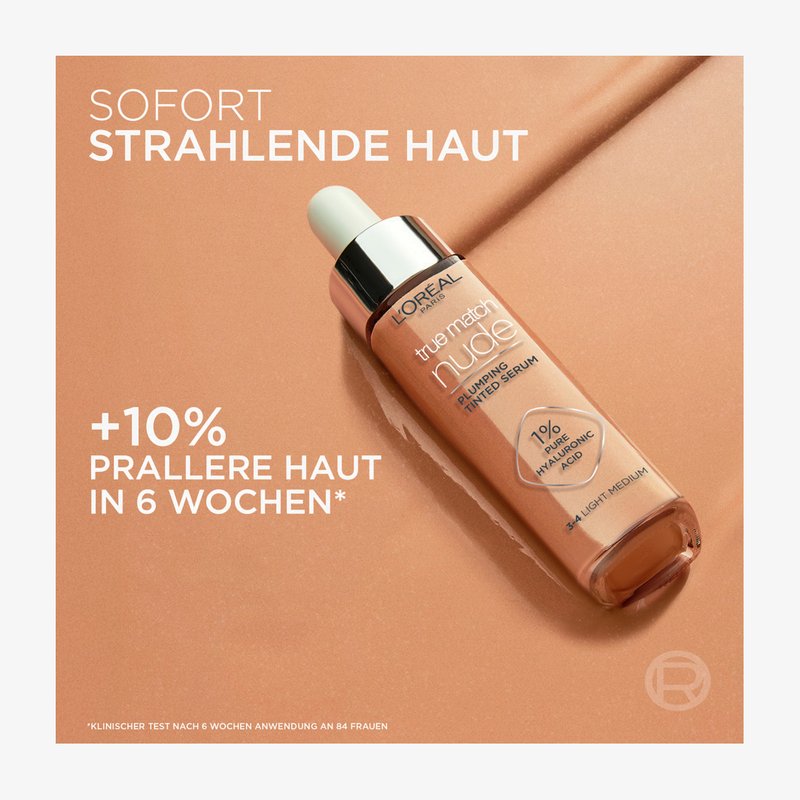 L’Oréal True Match Nude opstrammende tonet serumflaske på beige baggrund med tekst, der angiver 10 % fastere hud på 6 uger og hyaluronsyreindhold.