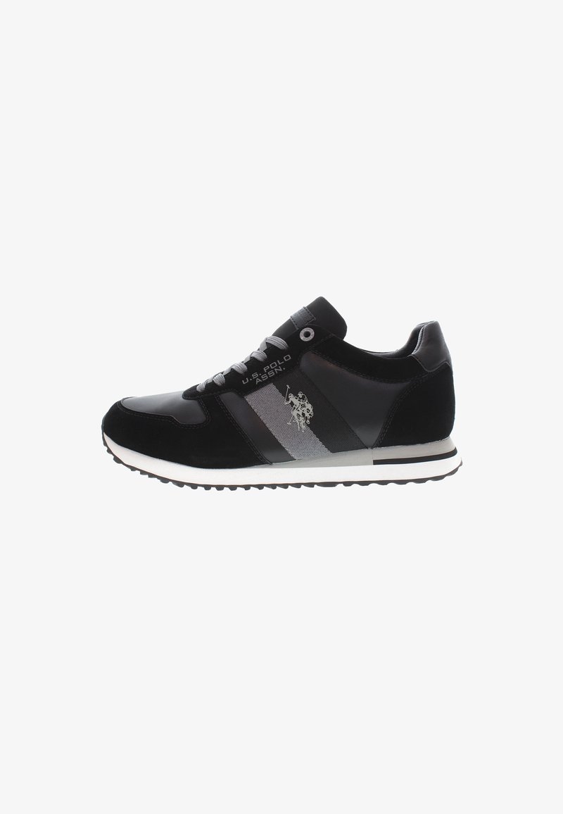 Schwarze Sportschuhe bestehen aus einer Mischung aus glattem Leder und Wildleder, mit silbernen Streifen und einer weißen Gummisohle mit rutschfester Struktur.