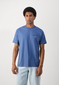 Blauwe katoenen t-shirt met korte mouwen, ronde hals en bedrukte tekst "ANTICO BAR" op de linkerkant van de borst. Losse pasvorm en een soepele textuur.