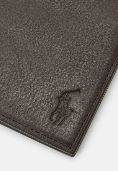 Brūna ādas maka ar teksturētu virsmu, kura priekšpusē ir iebukšķināts logotipa detaļa un gluda šuvuma apdare malās.