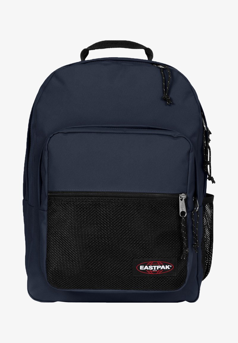 Mörkblå ryggsäck med svart meshfickor på framsidan, blixtlåsfack, starkt handtag och justerbara remmar. Eastpak-logotyp synlig.