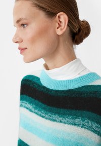 Knitted sweater featuring a wide round neckline, in shades of turquoise, black, and white with varying stripe patterns and soft texture.
