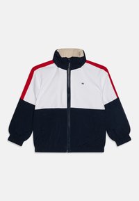 Farbblockierte Jacke mit marineblauen, weißen und roten Paneelen. Hergestellt aus leichtem Stoff mit hohem Kragen und elastischen Bündchen. Mit Reißverschluss.