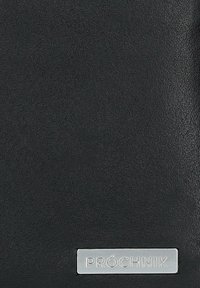 Czarny skórzany portfel o teksturowanym wykończeniu, z metalową płytką z logo, na której znajduje się napis "PRÓCHNIK" na dole.