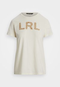 Kreminės spalvos medvilninė marškinė su tekstūruotu rudu "LRL" logotipu priekyje. Trumpomis rankovėmis ir apvaliu iškirpimu.