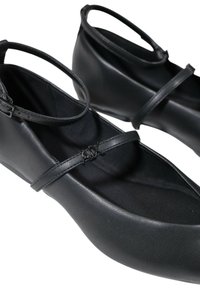 Bailarinas negras hechas de material sintético suave con punta redonda. Cuentan con una tira delgada en el tobillo y un pequeño detalle de logo en la tira.