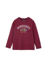 Dunkelrotes Langarmshirt mit dem Schriftzug "HOGWARTS" in weißer Schrift und vier bunten Hauswappen darunter. Hergestellt aus Baumwollstoff.