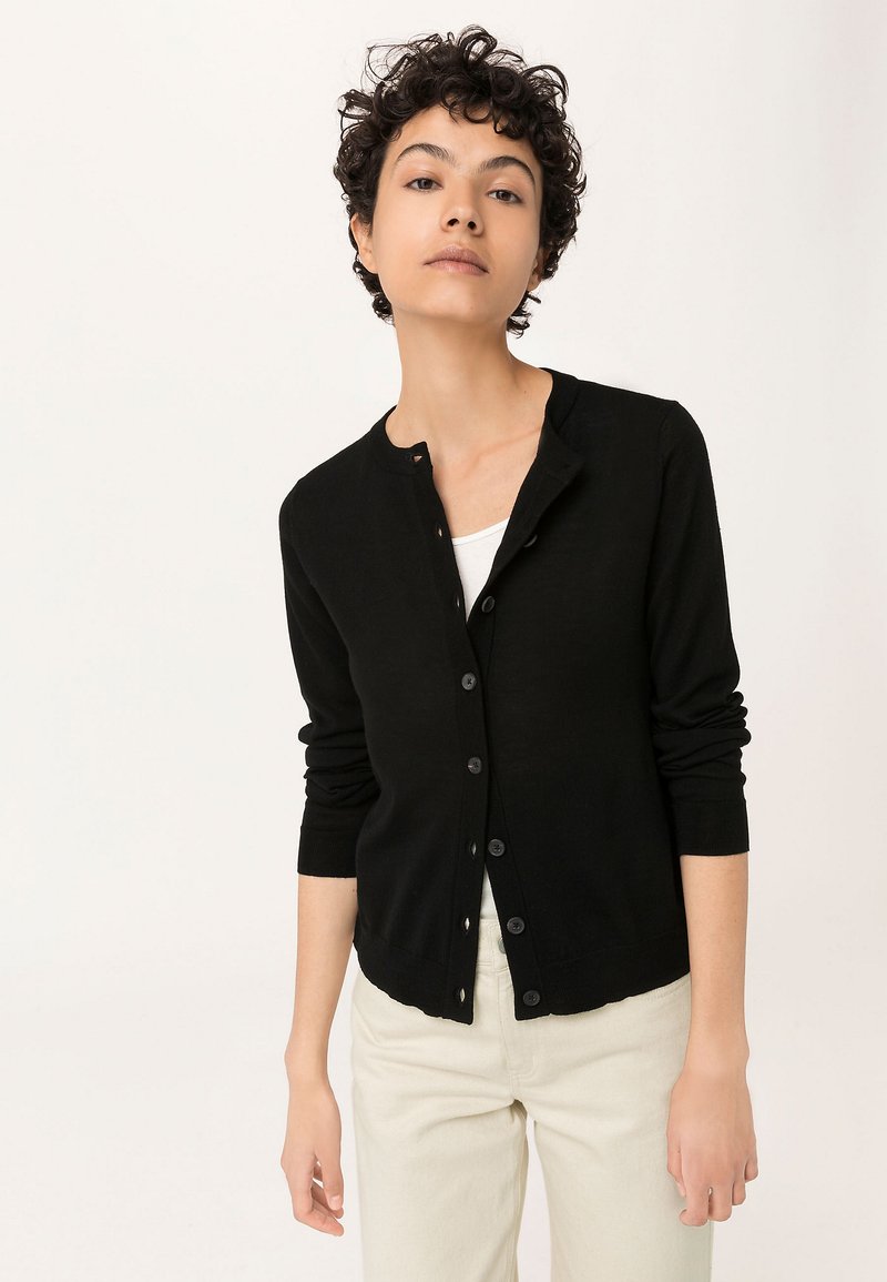 Schwarze Strickjacke mit runder Halslinie, langen Ärmeln und Knopfverschluss. Hergestellt aus weichem Material mit taillierter Passform.