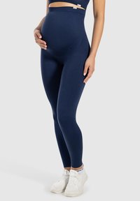 Leggings de maternité bleu marine avec une taille haute, fabriqués en tissu extensible, offrant une texture lisse et une silhouette ajustée.