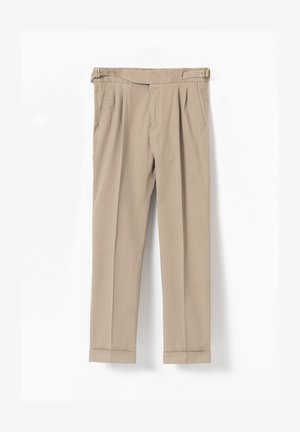 Pantalones beige plisados con hebillas ajustables laterales, bolsillos laterales, bajos con puño y un corte entallado adecuado tanto para ocasiones formales como informales.