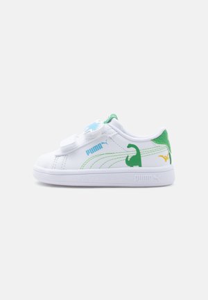 White Puma toddler sneaker with green dinosaur graphics, blue Puma logo, green heel tab, and velcro strap closure on a plain background.