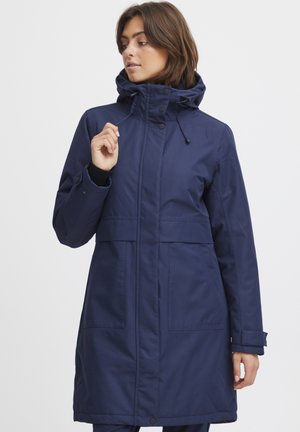 Parka imperméable navy avec un col haut, une capuche réglable et des poches avant. Dispose de fermetures à boutons et d'une texture lisse et mate.