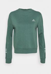 Sudadera verde hecha de un tejido suave. Presenta un cuello redondo y puños acanalados. Incluye un pequeño logotipo blanco de Adidas y tres rayas en las mangas.