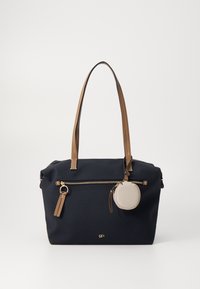 Mörkblå tygkasse med bruna läderhandtag, guldfärgad dragkedja och en fastsatt rund beige påse. Har subtila sömndetaljer.