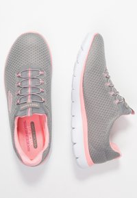 Szare buty sportowe z różowymi akcentami, fakturowana siateczkowa cholewka, sznurowany fason oraz biała podeszwa z amortyzacją dla wygody.