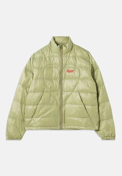 Világos zöld puffermellény magas gallérral, elől cipzárral, gyémánt mintázattal és hímzett vörös logóval a bal mellen.