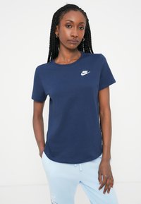 Námornícky modré bavlnené tričko s krátkymi rukávmi, okrúhlym výstrihom a bielym logom Nike na hrudi. Jednoduchý, klasický dizajn.
