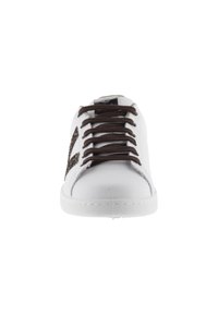 Baskets blanches avec lacets marron, présentant un accent marron texturé sur les côtés. Matériau lisse, bout arrondi et semelle en caoutchouc.