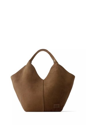Sac fourre-tout en daim marron doux avec une large ouverture en haut, des poignées arrondies et un petit patch embossé avec logo en bas à droite.