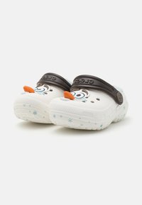 White clogs with a snowman face design, orange nose, and brown strap. Textured sole with blue snowflake accents. Lightweight material.