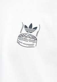 Parownik z trzema pierogami pod stylizowanym logo z trzema liśćmi na jednolitym białym tle.