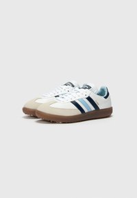 White and light blue sneakers with navy stripes, suede toe cap, and brown rubber sole. Features white laces and branded tongue label.