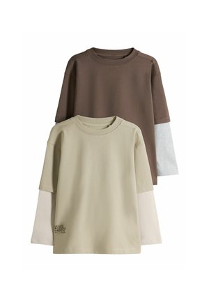 To lagdelte langærmede skjorter stablet, en beige med tekst "LEAVE NOTHING UNDONE" og en brun med lysegrå ærmer.