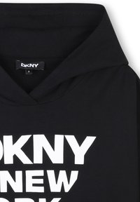 Felpa nera con cappuccio e una grande stampa bianca con la scritta "DKNY NEW YORK." Presenta una texture morbida e un design classico a pullover. L'etichetta della taglia è visibile.