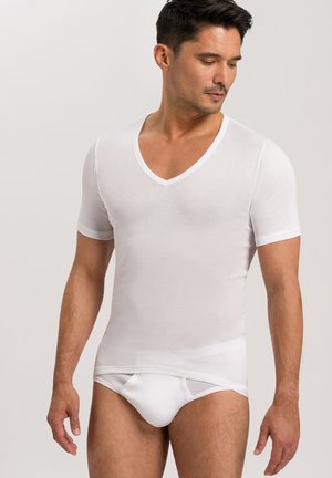 Weißes kurzes T-Shirt mit V-Ausschnitt aus glattem Stoff, taillierter Schnitt, leichtes Material, kombiniert mit weißen figurbetonten Slips.