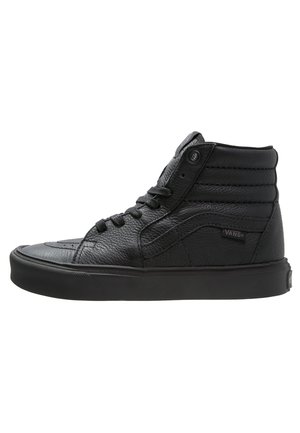 Czarny, wysokoprofilowy sneaker Vans z fakturowanej skóry, z przodu sznurowany, z wyściełanym kołnierzem wokół kostki i charakterystycznym bocznym paskiem.