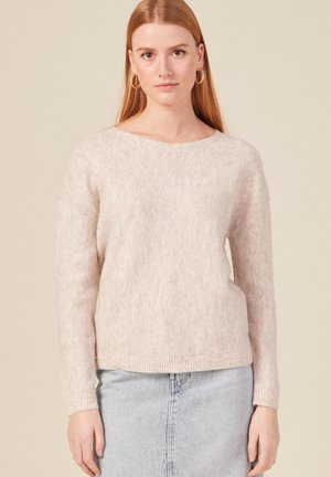Lichtroze sweater met visgraatpatroon, lange mouwen en een wijde halslijn. Zachte textuur en ribbelzoom. Draag het met een spijkerrok.