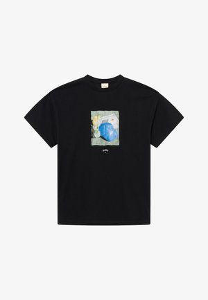 Black short-sleeve t-shirt featuring a central graphic of a blue cap, yellow flowers, and a white paper on a textured green background.