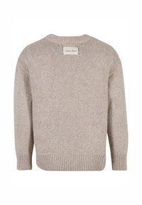 Beiger Strickpullover mit geripptem Saum und Bündchen, der ein strukturiertes Muster und ein rechteckiges Etikett am hinteren Kragen aufweist.