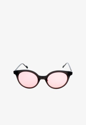 Occhiali da sole ovali neri con aste sottili e lenti leggermente rosa su sfondo bianco.