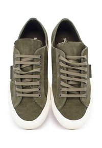 Zielono-oliwkowe zamszowe sneakersy o niskim kroju, z płaskimi sznurowadłami i białą gumową podeszwą; z metalowymi oczkami i brandingiem po bokach.