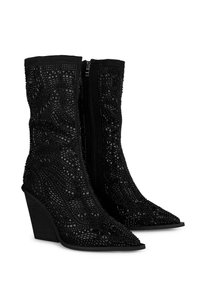 Bottes noires jusqu'au mollet avec orteils pointus, talons carrés, zip latéral et motifs géométriques texturés complexes couvrant la surface.