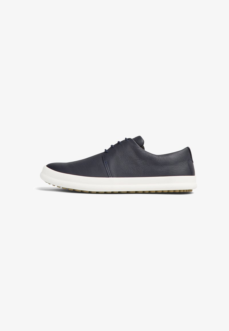 Marinblå lädersneaker med låg profil, rund tå, vit mellansula och texturerad gummisula; har minimal snörning och slät yta.