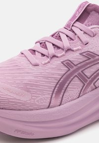 Rosa Sportschuh mit einem strukturierten Obermaterial, ausgestattet mit einer Schnürdesign, tonalen Logo-Akzenten und einer gepolsterten Zwischensohle, die mit "FF Blast+" gekennzeichnet ist.