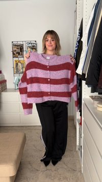 Cardigan oversized e cropped em listras alternadas de rosa e bordô, com textura de malha, apresentando cinco botões ao centro.