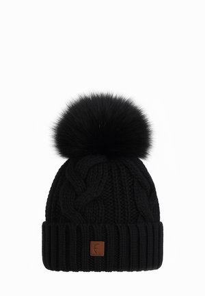 Black knitted beanie with cable pattern, wide ribbed cuff, large fluffy pom-pom on top, and small brown square leather logo patch on front.