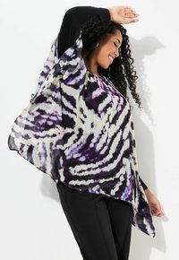 Top fluido con un corpo nero a maniche lunghe e un motivo tie-dye viola e bianco. Il tessuto leggero si drappeggia in modo elegante, creando una forma asimmetrica.