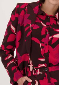 Bloemmotief blazer in donker bordeauxrood, met levendige roze en crèmekleuren, gestructureerd ontwerp en een enkele knoopsluiting.