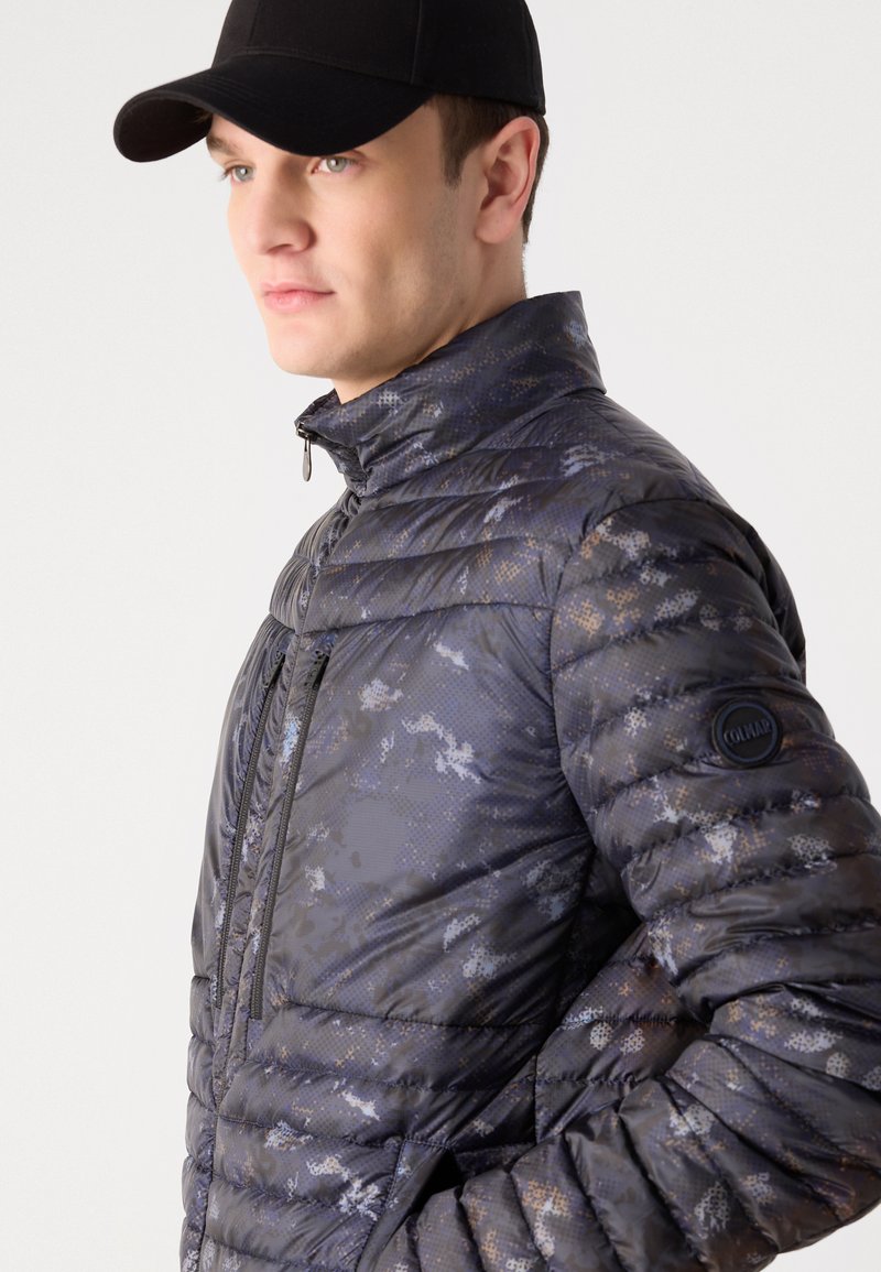 Kurtka puchowa w ciemnoszarym kolorze z niebieskim i brązowym wzorem kamuflażu. Posiada wysoki kołnierz, zamek błyskawiczny z przodu oraz naszywkę z logo na rękawie.